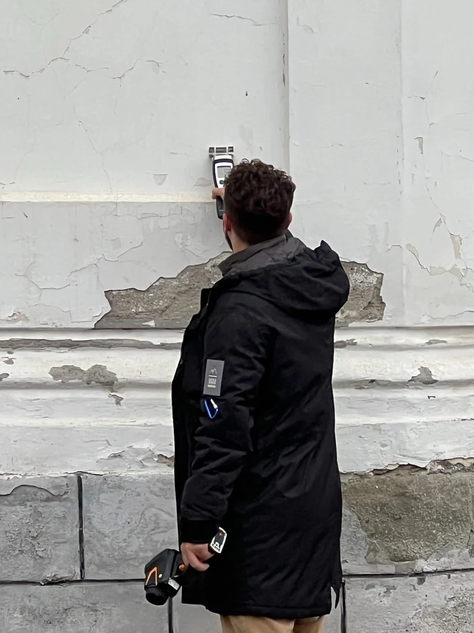 Alexandru Zorlescu taking measurements on an existing façade